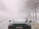 black car on road covered with fog