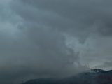 a cloudy sky over a snowy mountain