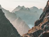 closeup photo of rocky mountain under blue and white sky
