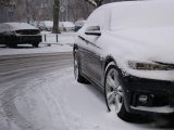 a car covered in snow on a snowy street