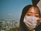 a woman wearing a face mask in front of a cityscape