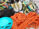 Close-up of mountain climbing gear including ropes, helmet, and harnesses for safety.