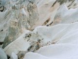 A mountain covered in snow with a sky background