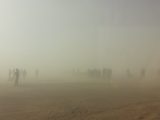 Atmospheric scene with silhouettes amidst sand and dust in Tindouf, Algeria.