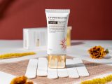 Close-up of SPF 60 UV protection cream for skincare, featuring floral accents and a natural setting.