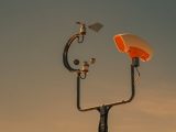 Weather monitoring equipment with a sunset sky backdrop, highlighting technology and atmosphere.