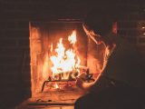 man in white and black checkered dress shirt sitting in front of bonfire
