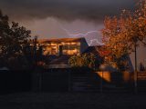A house with a lightning bolt in the background