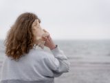 a woman holding a seashell up to her face
