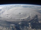 A stunning aerial view of Earth with a massive swirling hurricane, highlighting meteorological beauty.