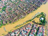 A striking aerial view of floodwaters in Hội An, Việt Nam, showcasing the city's streets and buildings submerged.