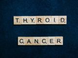 Scrabble tiles spelling 'Thyroid Cancer' on a dark blue background representing awareness.