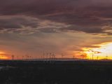 silhouette of wind turbines during sunset