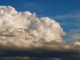 Cumulonimbus clouds forming a dramatic sky against a clear blue backdrop.