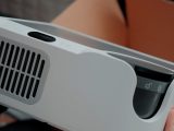 A white projector with ventilation slits.