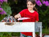 girl in red crew neck t-shirt holding white wooden fence