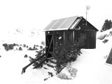 Wooden cabin with solar panels in snowy landscape