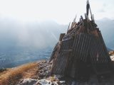 Dilapidated wooden structure on a mountain overlooking a valley.