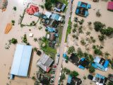 Drone view of a residential area in Kijal, Malaysia, showing extensive flooding and submerged buildings.