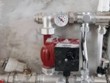 Close-up view of an industrial plumbing system featuring a pressure gauge and steel pipes.