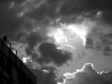 A striking black and white image featuring dramatic clouds over a building.