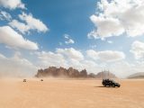 black car on brown sand under blue sky during daytime