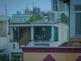 Urban rooftops in rain with water tanks and drying laundry, showcasing rainy day mood.