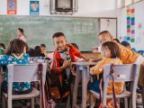 a group of children sitting at desks in a classroom