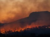 wildfire burning across hillside at dusk