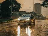 a car driving down a rain soaked street