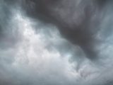 Dramatic storm clouds forming in the sky, signaling impending rain.