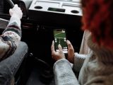 Two people using a navigation app on a smartphone during a road trip
