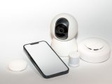 Collection of smart home security gadgets with a smartphone display.