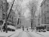 a black and white photo of a snowy street