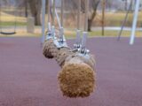 Several rope swings hanging over a rubber playground surface