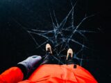 High angle view of a person in winter clothing standing on cracked ice, showcasing a unique perspective.