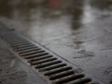 A metal drain on a wet concrete surface